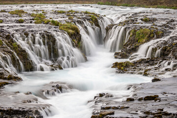 smooth white water cascading through lava rocks, Brúarfoss , South Iceland