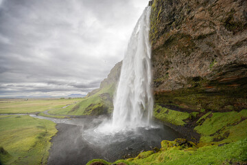 Seljalandsfoss waterfall with the path leading behind the cascades, Iceland