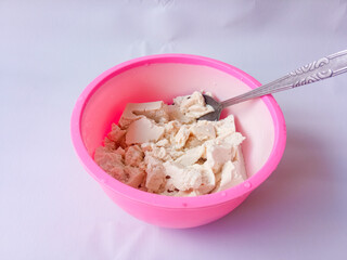 Tofu crushed with a spoon in a bowl isolated on white