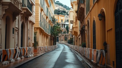 Fototapeta premium The narrow streets of Monaco Formula One circuit, lined with barriers, with no vehicles or people in sight, capturing the city's architecture.