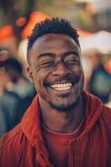 Fototapeta premium A smiling man wears a bright red jacket, his eyes shut tight