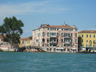 Romantic Venetian landscape. Tourists in a gondola on a walk along a Grand Canal in the old town. Famous historical heritage city.