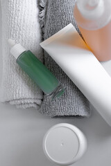 Skincare products arranged artistically on a textured gray towel in soft natural light