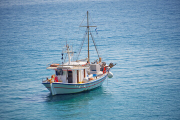 Obraz premium A greek fishing boat in the middle of the blue sea
