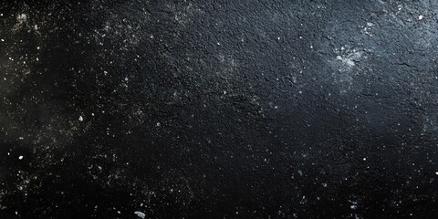 Fototapeta premium A textured black surface with scattered light specks resembling a cosmic scene.
