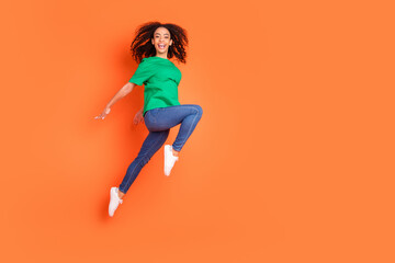 Photo of young funky sportive energetic girl feeling carefree jumping when female periods isolated on orange color background