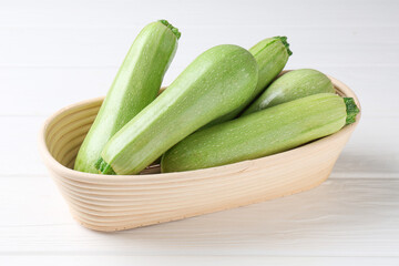Fresh ripe zucchinis on white wooden table, closeup