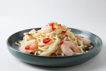 Delicious pasta with shrimps, green onion and chili pepper on white table, closeup