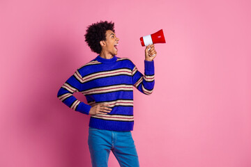 Photo of eccentric man guy with wavy hair dressed knitwear sweater scream in megaphone look empty space isolated on pink color background