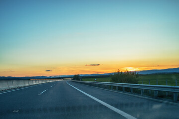 Fototapeta premium View of the highway from car during sunset.