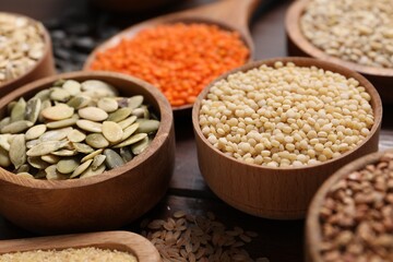 Different types of cereals, seeds and legumes on table, closeup