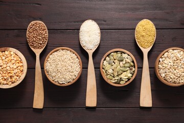 Different types of cereals and seeds on wooden table, flat lay