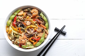 Stir-fry noodles with sea food served on white wooden table, flat lay