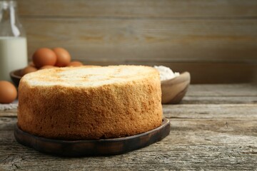 Tasty sponge cake on wooden table, space for text