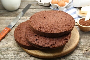 Cut chocolate sponge cake and ingredients on wooden table