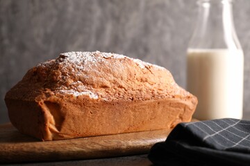 Tasty sponge cake with powdered sugar on grey table, closeup