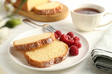 Freshly baked sponge cake and raspberries on white wooden table