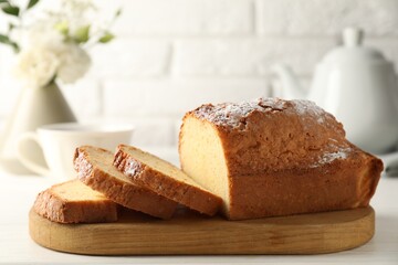 Freshly baked sponge cake on white wooden table, closeup