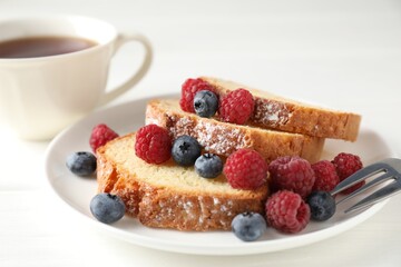 Freshly baked sponge cake, raspberries and blueberries on white wooden table, closeup
