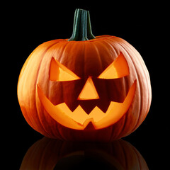 Fototapeta premium Miniature Jack O Lantern face for Halloween isolated on black. Carved pumpkin in dark night. Holiday