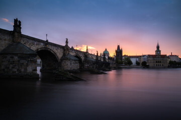 View of Charles Bridge in Prague during sunrise in the early morning with dramatic sky. Vltava river. Czech Republic.