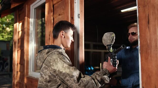 Tag uniform, Uniform equipment, Uniform attire. Player in paintball is equipped with Paintball essentials such as safety helmet, outfit, and weaponry.