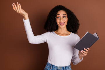 Portrait of nice young woman hold book rehearsal wear pullover isolated on brown color background