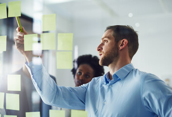 Idea, writing and business people in meeting on glass for planning, discussion and tasks in office....