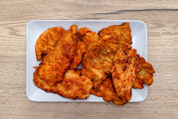Chicken fillet cutlets coated with breadcrumbs and fried in a pan lying on a plate.