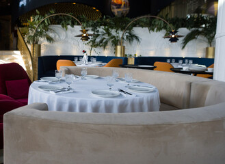modern table setting in a trendy restaurant. Sofa, armchair, table and dishes on the table