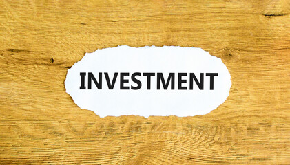 Investment symbol. Concept word Investment on beautiful white paper. Beautiful wooden wall background. Business investment concept. Copy space.