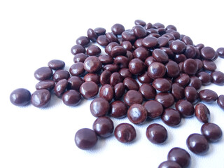 Chocolate coated peanut candy or chocolate balls isolated on white background