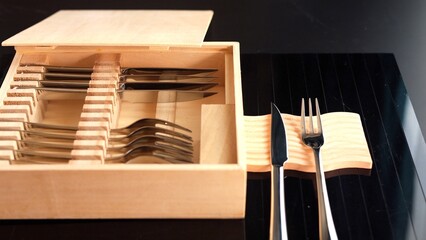 Modern wooden cutlery box with silver utensils neatly organized. Sustainable materials and minimalist design offer eco-conscious, elegant solution for practical dining with stylish presentation.