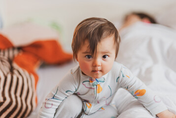 The little baby girl refuses to go to sleep even though her mother is very tired and already sleeping