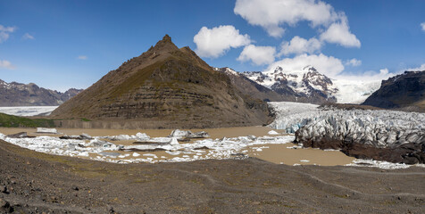 panorama view of  Svínafellsjökull Glacier, mountain peaks, glacier lagoon and iceberg on a sunny...
