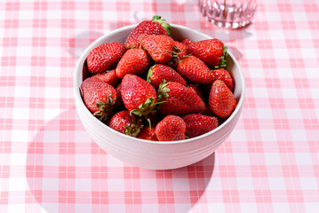 strawberries in a bowl on a pink background