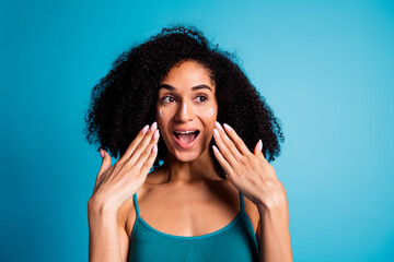 Photo of excited girl look with cream lotion on her face isolated blue color background