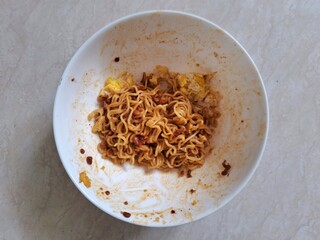 A bowl of fried instant noodles from Indonesia that has been eaten half