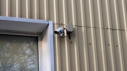 A camera is mounted on a wall next to a window
