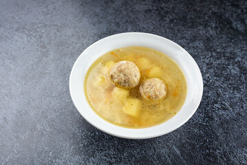 A bowl of soup with meatballs in it