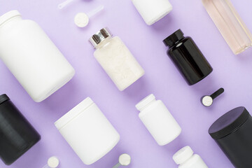 Jars with protein powder on color background, top view. Sports nutrition concept