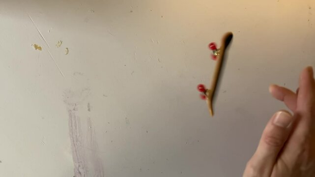 top shot of fivefold heel flip, fingerboarding trick on desk, 4k footage.