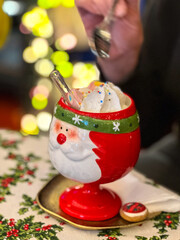 Hot winter drink in Santa Claus cup. Cocoa marshmallow sweet beverage. Christmas New Year's drink.