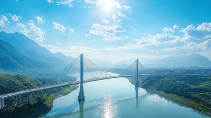 Obraz premium A breathtaking view of a bridge stretching across a wide river with mountains in the background, under a bright blue sky, illustrating the grandeur of nature and human engineering.