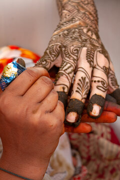 Close-up of a Henna tattoo (mehendi) being applied to a woman's hand before an Indian wedding