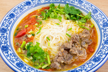 A bowl of tomato beef brisket sour soup rice noodles