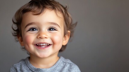 Fototapeta premium A baby boy with blond hair laughs as he looks up.