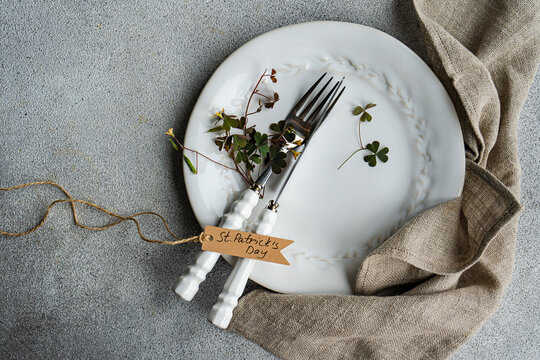 Overhead view of a place setting on a table with fresh shamrock leaves and a St Patrick's Day tag