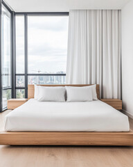 Fototapeta premium Modern minimalist bedroom with large windows overlooking an urban skyline during daylight
