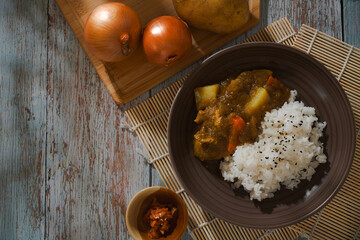 Japanese curry rice served in brown ceramic bowl.